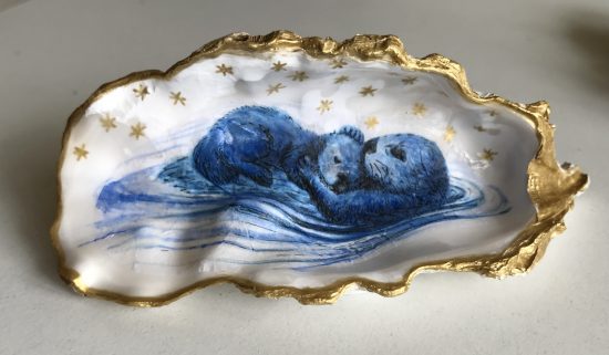 sea otter mother and pup in gilded oyster shell
