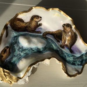 rivers otters play in the snow on an oyster shell