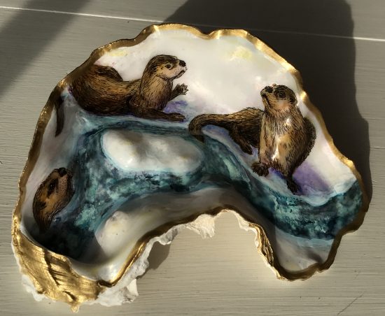 rivers otters play in the snow on an oyster shell