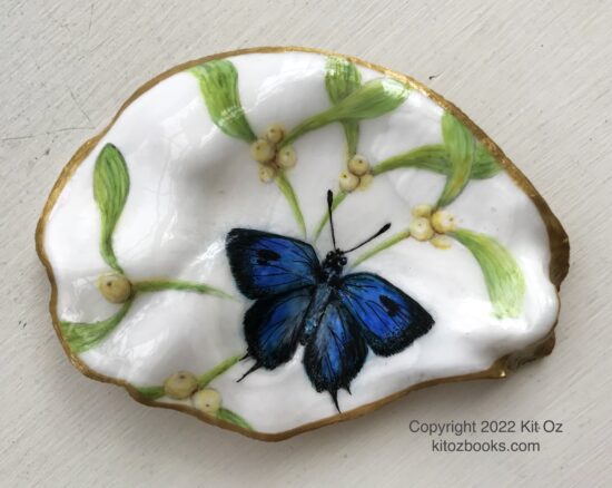blue butterfly and green mistletoe painted inside an oyster shell with gold trim