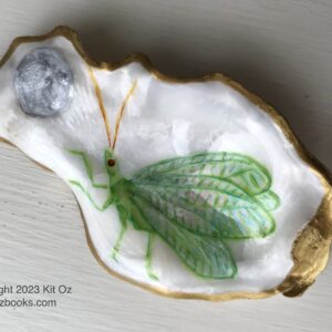 a delicate, pale green winged bug raises a tiny front leg in a gesture toward a silvery moon, all painted inside a small oyster shell