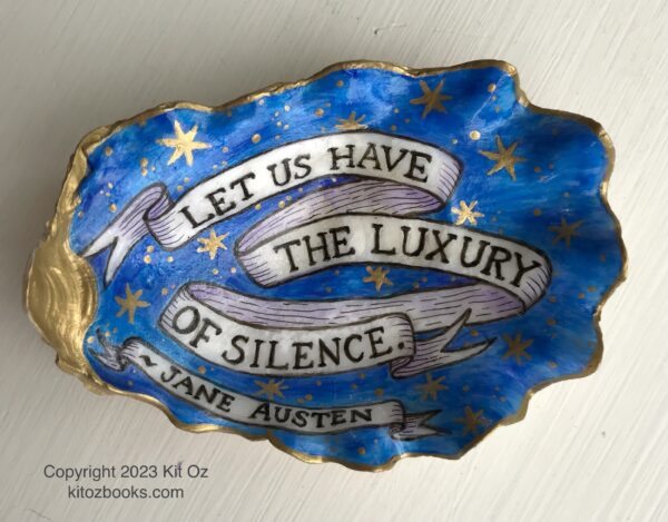 oyster shell painted with a quotation from Jane Austen, "Let us have the luxury of silence." Words are on a banner, with a background of deep blue with gold stars.
