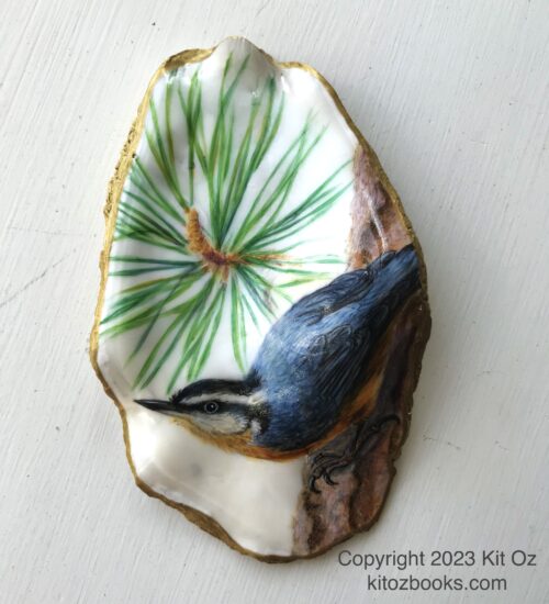 An oyster shell with a grey-blue nuthatch bird painted on it. Burst of pine needles in the background.