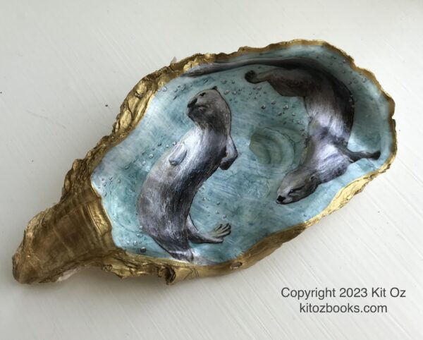 An oyster shell with gold trim. Inside it is painted a scene of two river otters swimming underwater. Blue-green background.